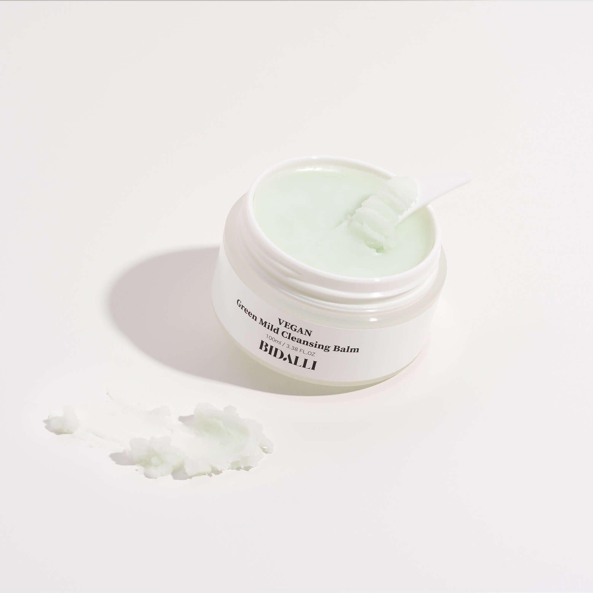 Open jar of Bidalli Vegan Green Mild Cleansing Balm with spatula and balm texture swatch on white surface, gentle sherbet-type vegan cleanser for sensitive skin
