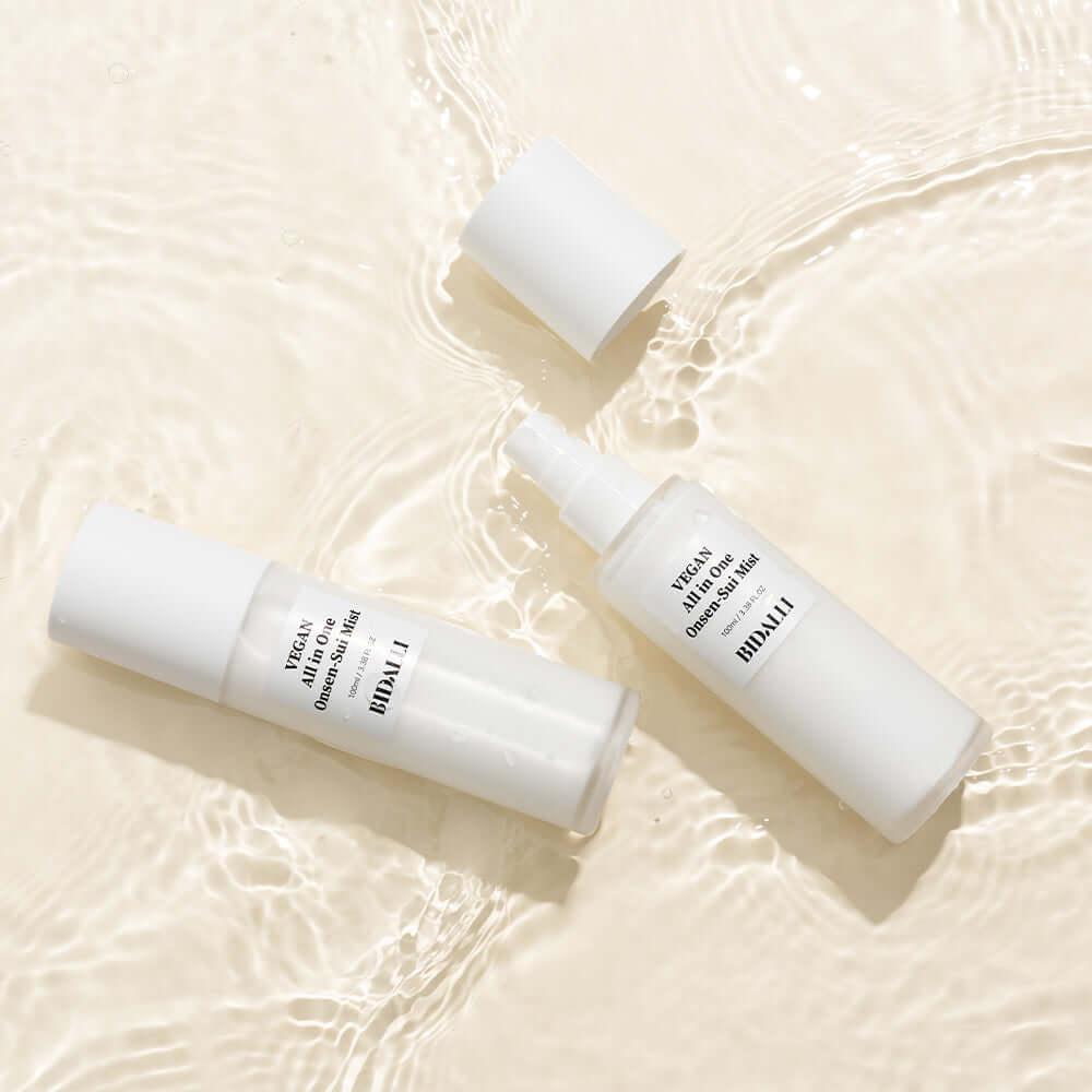 Bidalli Vegan All in One Onsen-Sui Mist bottles floating in rippling water, hydrating vegan facial mist with mineral-rich onsen water for refreshing skincare