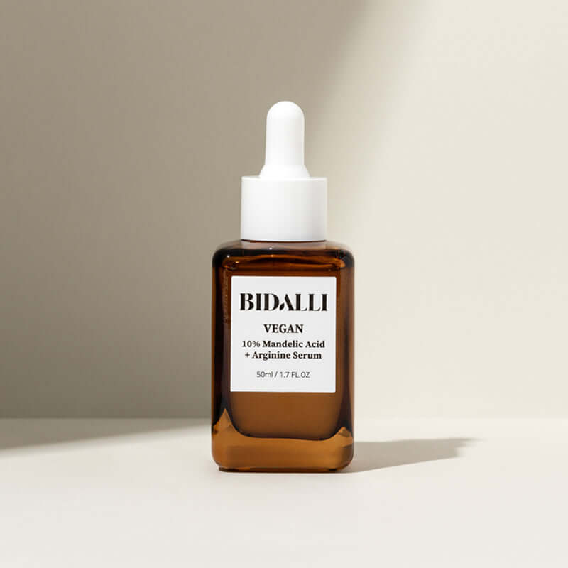 Bidalli 10% Mandelic Acid + Arginine Serum in amber glass bottle with dropper cap - vegan exfoliating serum for sensitive skin, photographed in soft natural light